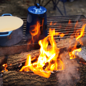 camping food ideas start with a great campfire -- this campfire setup uses a grate over the top of the fire.
