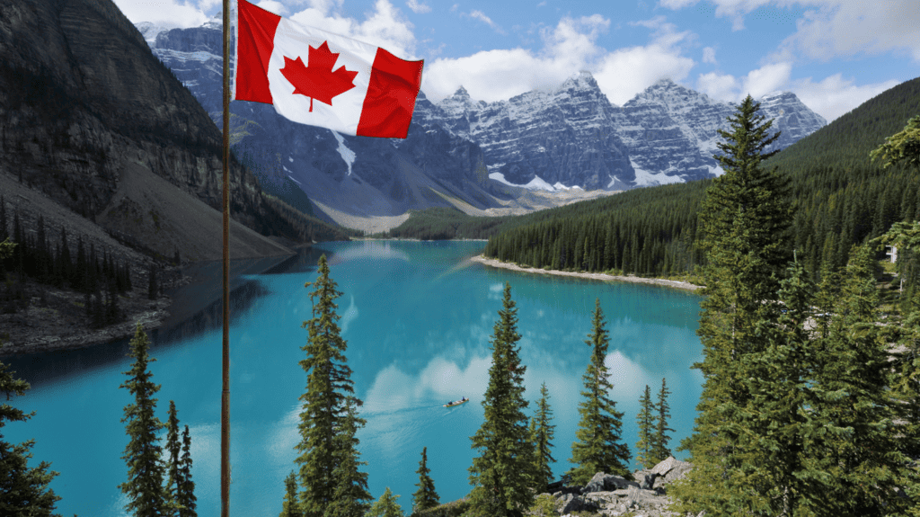 Moving to Canada from US: Canadian Flag flying in front of a turquoise blue alpine lake