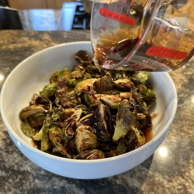 Drizzling Honey Balsamic Glaze over Roasted Brussels Sprouts